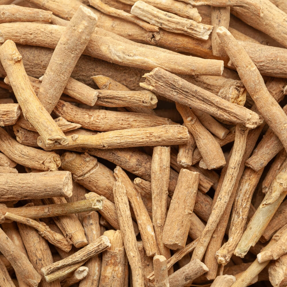 A close-up pile of dried, light brown root sticks with rough, textured bark surfaces.