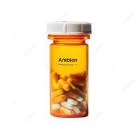 An amber plastic pill bottle with a white ribbed cap, labeled ’Ambien’ with ’PR Probability’ underneath, containing yellow and white capsules, isolated on a white background.